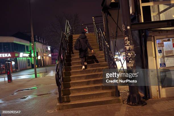 Woman walks up a set of stairs at a street overpass in Warsaw, Poland on 21 February, 2024.