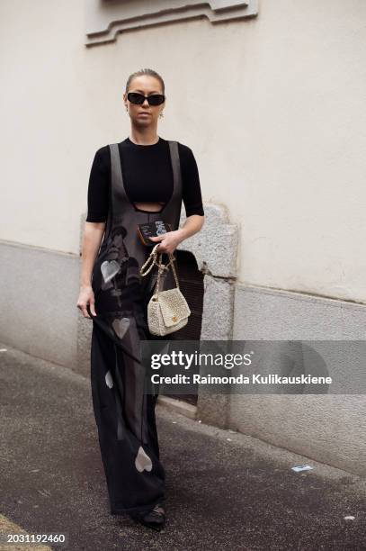 Jenifer Nelly Steen wears a black crop top, a long black maxi dress with a pattern, and a white creme bag outside Anteprima during the Milan Fashion...