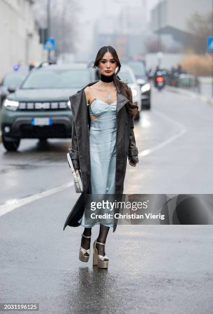 Heart Evangelista wears black coat, blue dress, white bag outside Prada during the Milan Fashion Week - Womenswear Fall/Winter 2024-2025 on February...