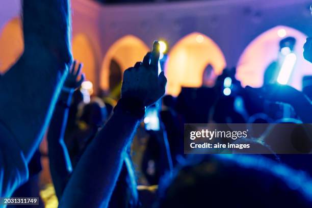 irresponsible group of people with washed hands at a night party with colored lights. - club photos et images de collection