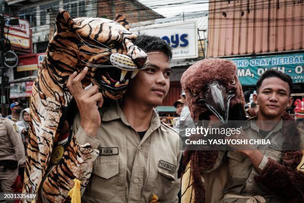 Members of local brass band prepare to march during the Cap Go Meh festival, to mark the last day of the Lunar New Year of the Dragon, on the street...