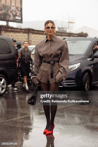 Negin Mirsalehi wears black tights, red shoes, a brown shirt tugged into brown mini shorts, a black belt, brown sunglasses, and black Prada bag...