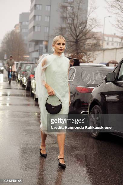 Caroline Caro Daur wears a mint green sheer dress, black shoes, and a black Prada bag outside Prada during the Milan Fashion Week - Womenswear...