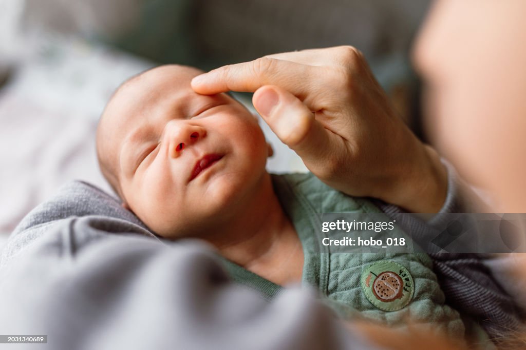 Little baby boy enjoying in mother's touch