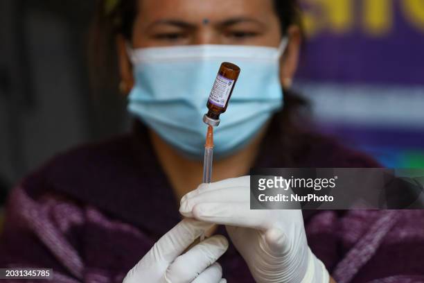 Nepali paramedic is preparing a dose of the anti-measles-rubella vaccine as she gets ready to administer it during the nationwide vaccination...