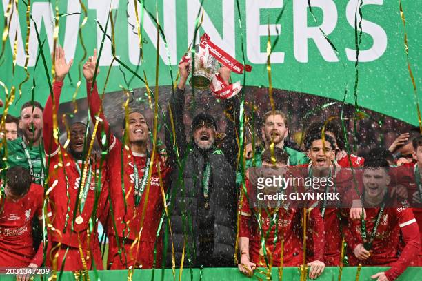Liverpool's German manager Jurgen Klopp and Liverpool's Dutch defender Virgil van Dijk lift the trophy after the English League Cup final football...