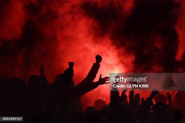 Liverpool fans celebrate Liverpool's Dutch defender Virgil van Dijk's winning goal by lighting flares during the English League Cup final football...