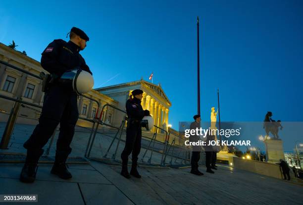 Austrian policemen stand guard as demonstrators gather to attend a 'Sea of Lights' protest against racism and far-right politics in front of the...