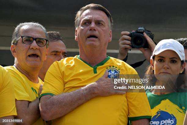 Former Brazilian President Jair Bolsonaro sings the national anthem next to his wife Michelle Bolsonaro and Pastor Silas Malafaia during a rally in...