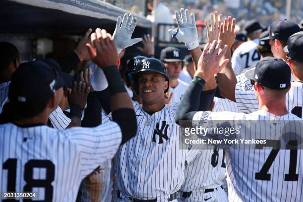 Juan Soto of the New York Yankees high fives teammates after hitting a home run during a spring training game against the Toronto Blue Jays at George...