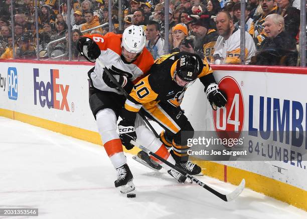 Travis Sanheim of the Philadelphia Flyers and Drew O'Connor of the Pittsburgh Penguins battle for the loose puck at PPG PAINTS Arena on February 25,...