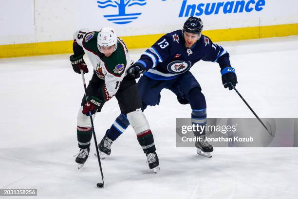 Alex Kerfoot of the Arizona Coyotes plays the puck away from Gabriel Vilardi of the Winnipeg Jets during first period action at the Canada Life...