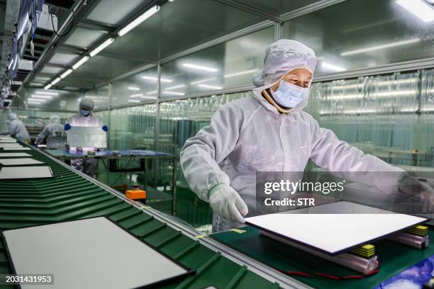 An employee works on a LCD monitors production line at a workshop in Ruichang, in central China's Jiangxi province on February 26, 2024. / China OUT