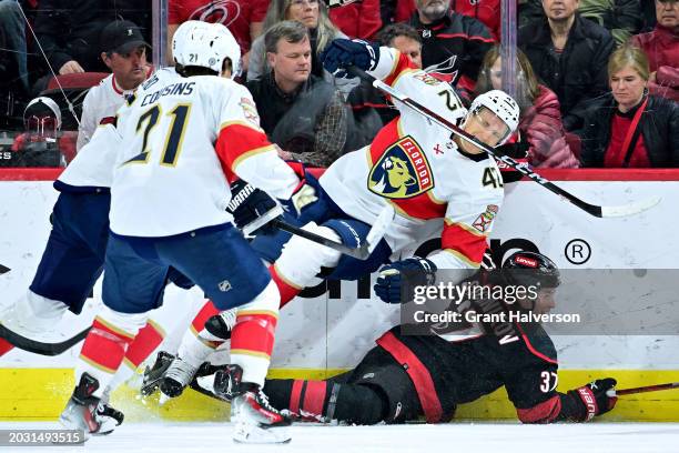 Gustav Forsling of the Florida Panthers trips over Andrei Svechnikov of the Carolina Hurricanes during the first period of the game at PNC Arena on...