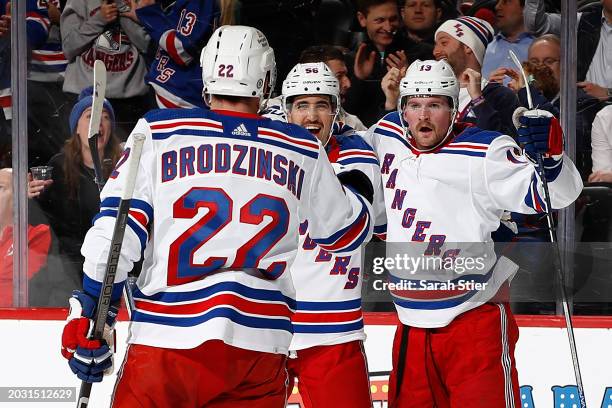 Jonny Brodzinski and Erik Gustafsson celebrate with Alexis Lafreniere of the New York Rangers after his goal scored during the first period against...