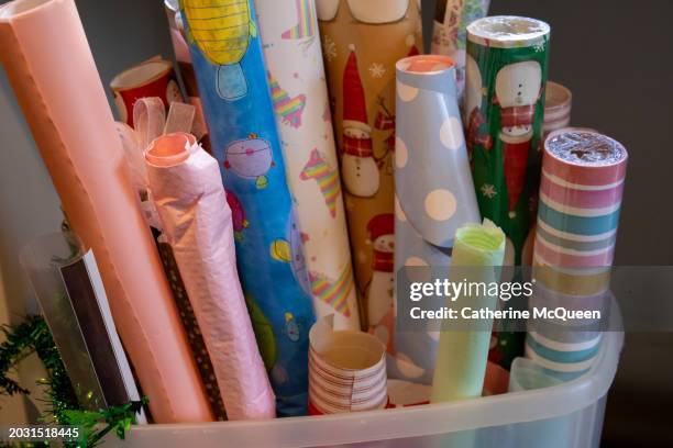 rolls of gift wrapping paper in storage container - christmas wrapping paper rolls stock pictures, royalty-free photos & images