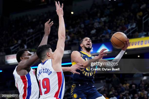 Tyrese Haliburton of the Indiana Pacers attempts a layup while being guarded by Jalen Duren and Simone Fontecchio of the Detroit Pistons in the first...