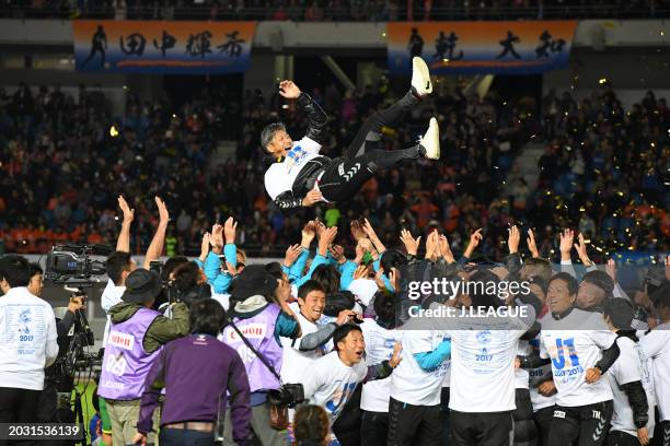 Head coach Takuya Takagi of V-Varen Nagasaki is tossed into the air as the team celebrates the promotion to the J1 following the 3-1 victory in the...