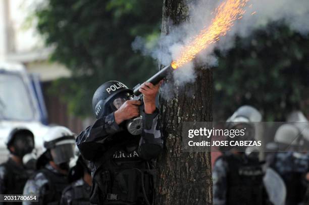 Riot squad agent shoots a tear gas canister at supporters of ousted Honduran President, Manuel Zelaya, in an effort to drive them away from the...