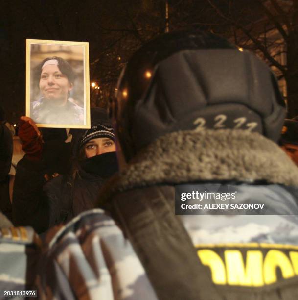 Russian activist holds a portrait of slain newspaper reporter Anastasia Baburova during a rally in Moscow on January 19, 2010 to mark one year from...