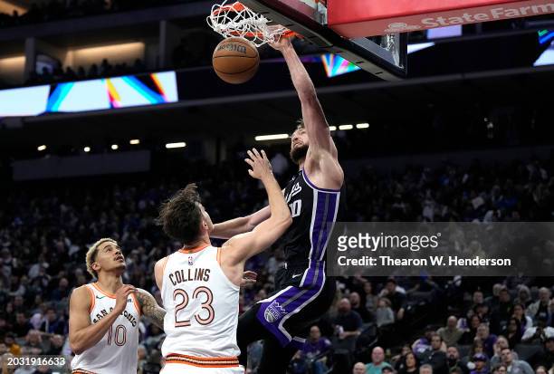 Domantas Sabonis of the Sacramento Kings slam dunks over Zach Collins of the San Antonio Spurs in the fourth quarter at Golden 1 Center on February...