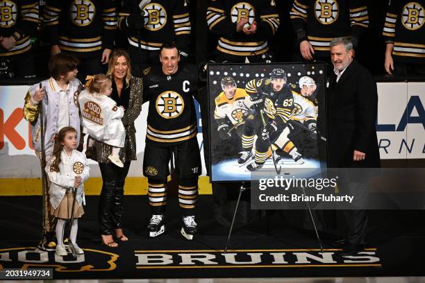 Brad Marchand of the Boston Bruins and his family pose for a picture with Bruins president Cam Neely during a ceremony for playing in 1,000 NHL games...