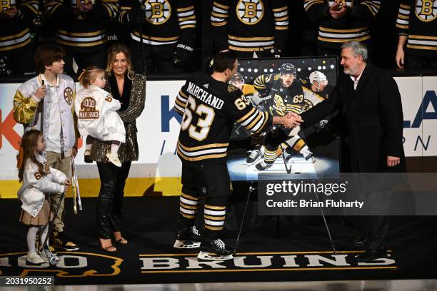 Brad Marchand of the Boston Bruins shakes hands with Bruins president Cam Neely during a ceremony for playing in 1,000 NHL games before a game...