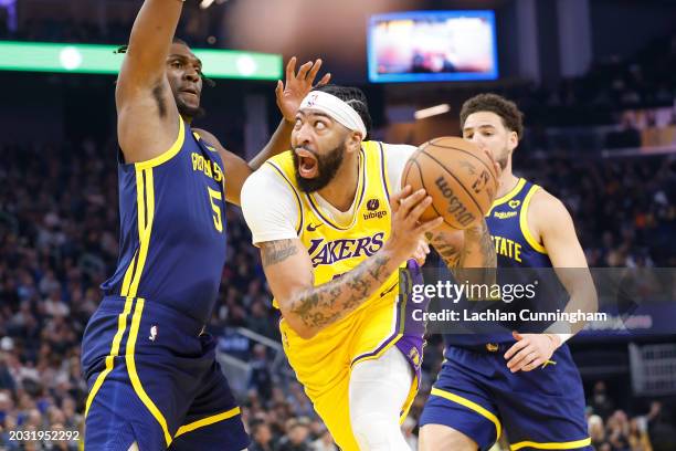 Anthony Davis of the Los Angeles Lakers goes to the basket against Kevon Looney of the Golden State Warriors in the first half at Chase Center on...