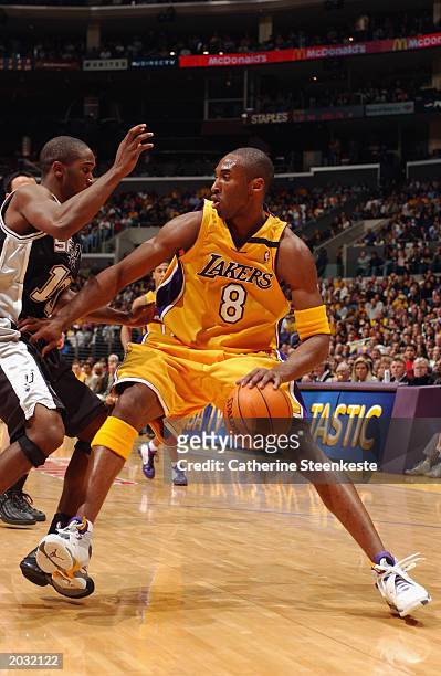 Kobe Bryant of the Los Angeles Lakers drives around Speedy Claxton of the San Antonio Spurs in Game three of the Western Conference Semifinals during...