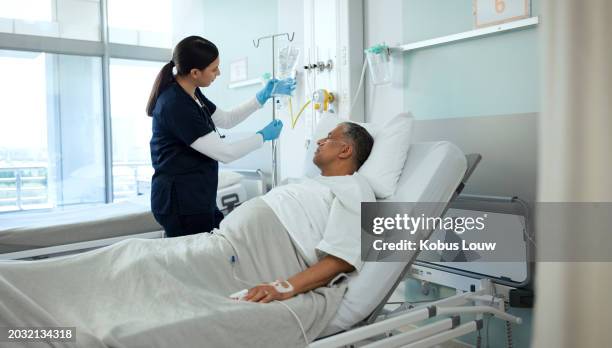 frau, krankenschwester und älterer patient mit tropf für die gesundheitsversorgung, genesung oder medizin auf dem bett im krankenhaus. weibliche person, medizinisches personal oder heilpraktiker, die einem älteren mann bei der änderung der behandlung o - intensivmedizin stock-fotos und bilder