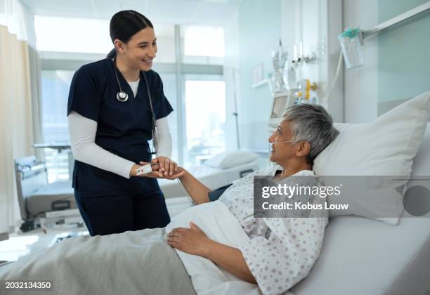 patient, hospital and bed with caregiver, support and senior woman with healthcare and medical help. clinic, conversation and consultation with nurse about wellness, health and surgery with doctor - critical care stock pictures, royalty-free photos & images