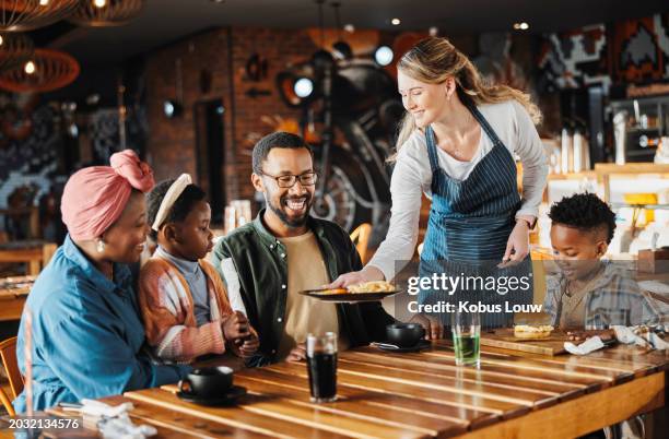 family, lunch and service of waiter at restaurant with plate, fun and eating at diner together. customer, table and server at cafe with food for happy african parents, children and relax at gathering - serveur restaurant stock pictures, royalty-free photos & images