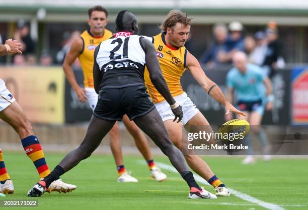 Luke Pedlar of the Crows kicks past Aliir Aliir of the Power during an AFL practice match between Port Adelaide Power and Adelaide Crows at Alberton...