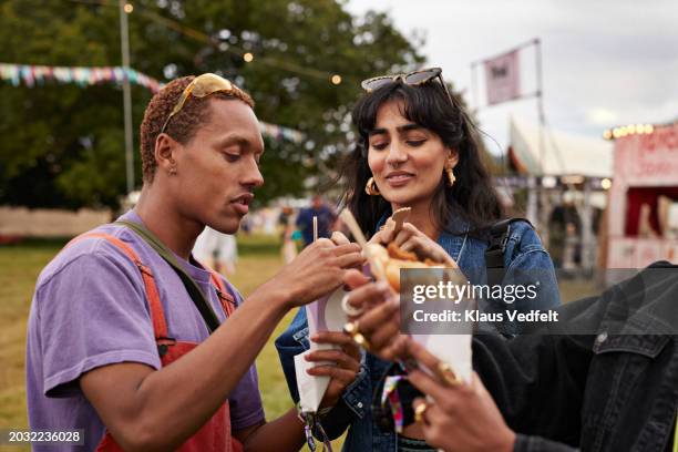 friends sharing dessert at music festival - street food festival stock pictures, royalty-free photos & images