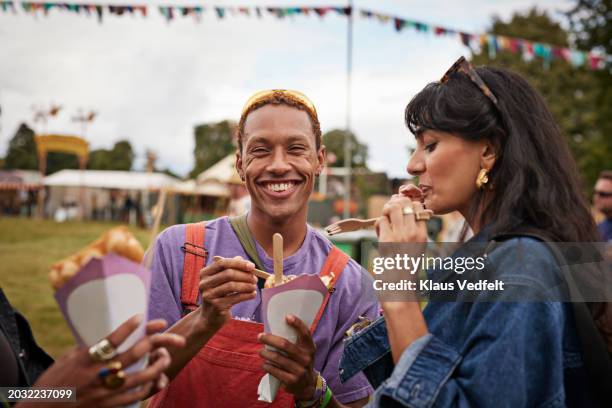 happy young man sharing dessert with female friend - mr purple stock pictures, royalty-free photos & images