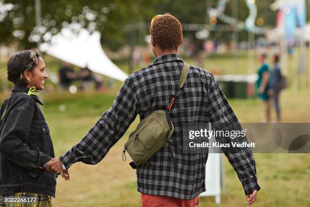 young couple holding hands while walking - crossbody bag stock pictures, royalty-free photos & images
