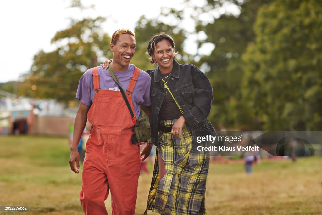 Happy woman walking with arm around boyfriend