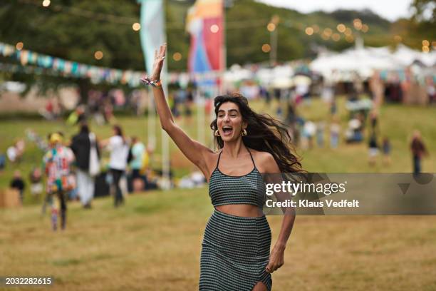 excited woman with raised hand running at park - green skirt stock pictures, royalty-free photos & images