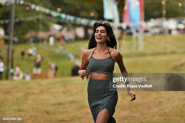 excited woman running while laughing at park - green skirt stock pictures, royalty-free photos & images