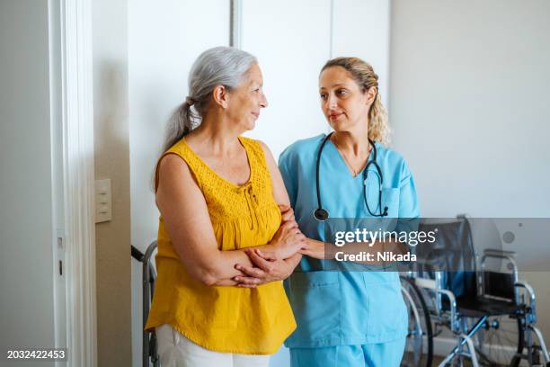 une infirmière attentionnée avec une femme âgée dans une conversation réconfortante - contact avec les patients photos et images de collection