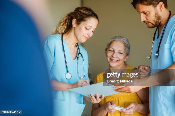 caring healthcare professionals consulting happy elderly woman - body care stock pictures, royalty-free photos & images