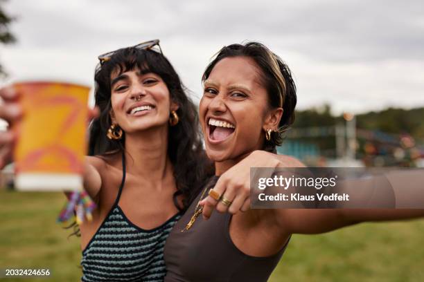 cheerful woman shouting with female friend - black hair stock pictures, royalty-free photos & images