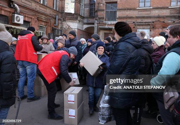 Local residents receive food kits distributed by volunteers of the NGO "Responsible Citizens" with the financial support of the UK Government, in...