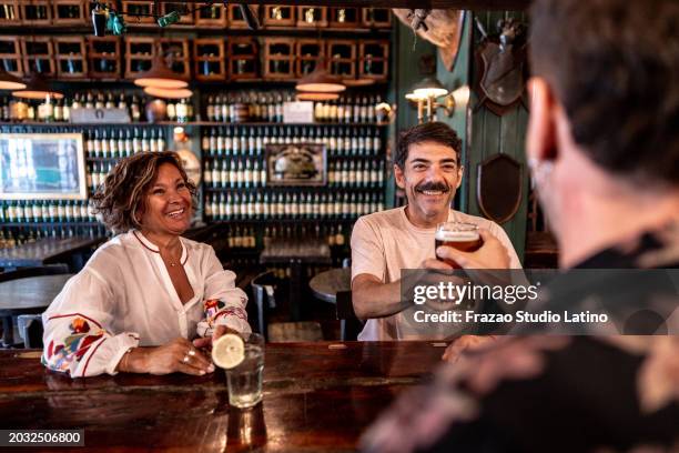 bartender serving beer to customer at bar counter - 60s cocktail party stock pictures, royalty-free photos & images