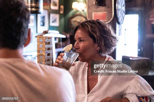 senior woman drinking cocktail at the pub - 60s cocktail party stock pictures, royalty-free photos & images