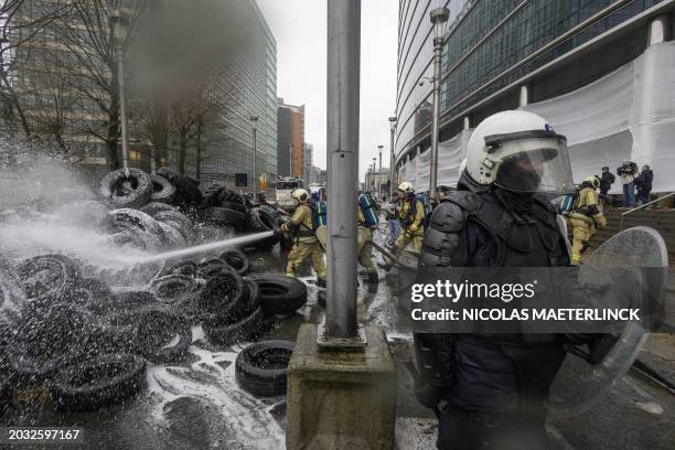 Firemen extinguish burning tires during a protest action of farmers' organizations 'Federation Unie de Groupements d'Eleveurs et d'Agriculteurs' ,...