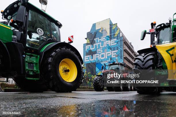 Tractors are stationed near a building bearing a mural reading "The future is Europe" during a protest called by the farmers' organizations...