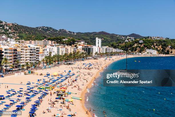 beach with tourists in lloret de mar on a sunny summer day, costa brava, spain - barcelona province stock pictures, royalty-free photos & images