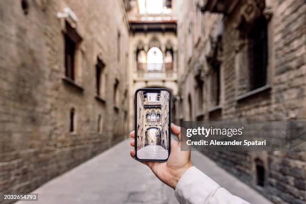 tourist taking photo of a street in gothic quarter in barcelona using smart phone, personal perspective view, spain - gothic man stock pictures, royalty-free photos & images