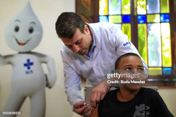 Rio de Janeiro's Health Secretary Daniel Soranz applies a dose of the Qdenga dengue vaccine to Bruno Lima during the first day of massive vaccination...